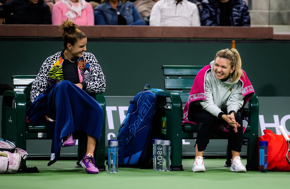 Sakkari and Halep share a laugh as they watch the third tiebreak between Badosa and Fernandez.