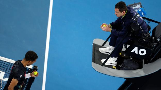 Felix Auger-Aliassime speaks to the chair umpire about the quality of the tennis balls