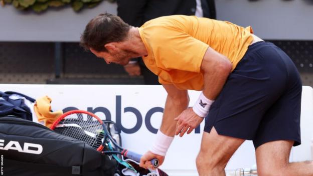 Andy Murray whacks his racquet against his bag at the Madrid Open
