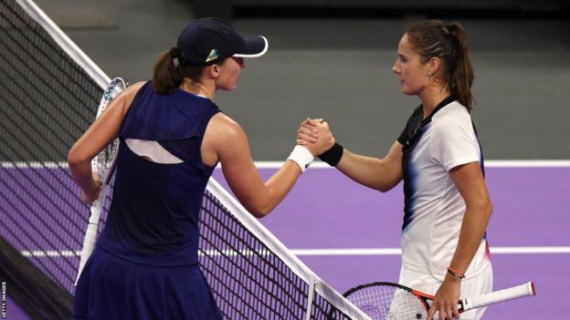 Iga Swiatek shakes hands with Russian Daria Kasatkina at the net after their match at the 2022 WTA Finals
