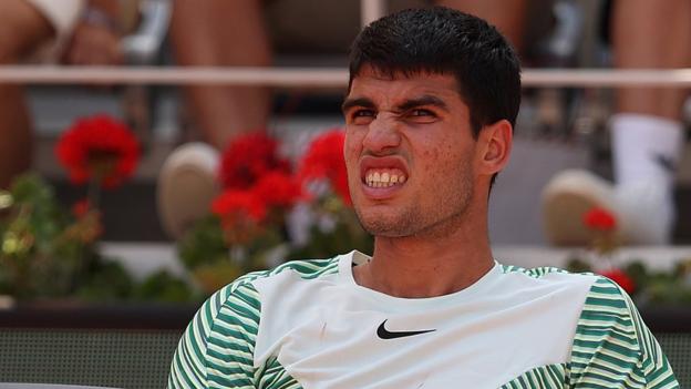 Carlos Alcaraz grimaces during his French Open semi-final against Novak Djokovic