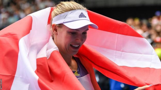 Caroline Wozniacki wraps herself in a Denmark flag at the 2020 Australian Open