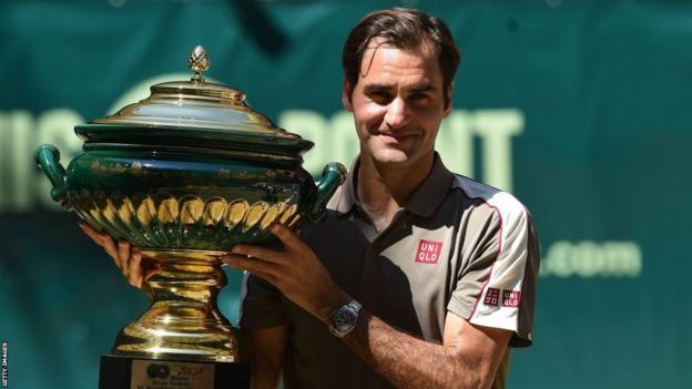 Roger Federer poses with a trophy after winning an ATP tennis tournament in Halle in 2019