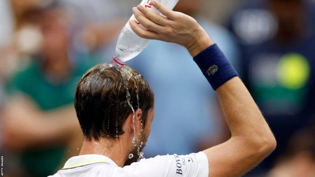 Daniil Medvedev tries to cool himself down by pouring water over his head