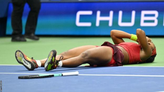 Coco Gauff lies on the ground after winning US Open title