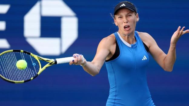 Caroline Wozniacki of Denmark returns a shot against Jennifer Brady of the United States