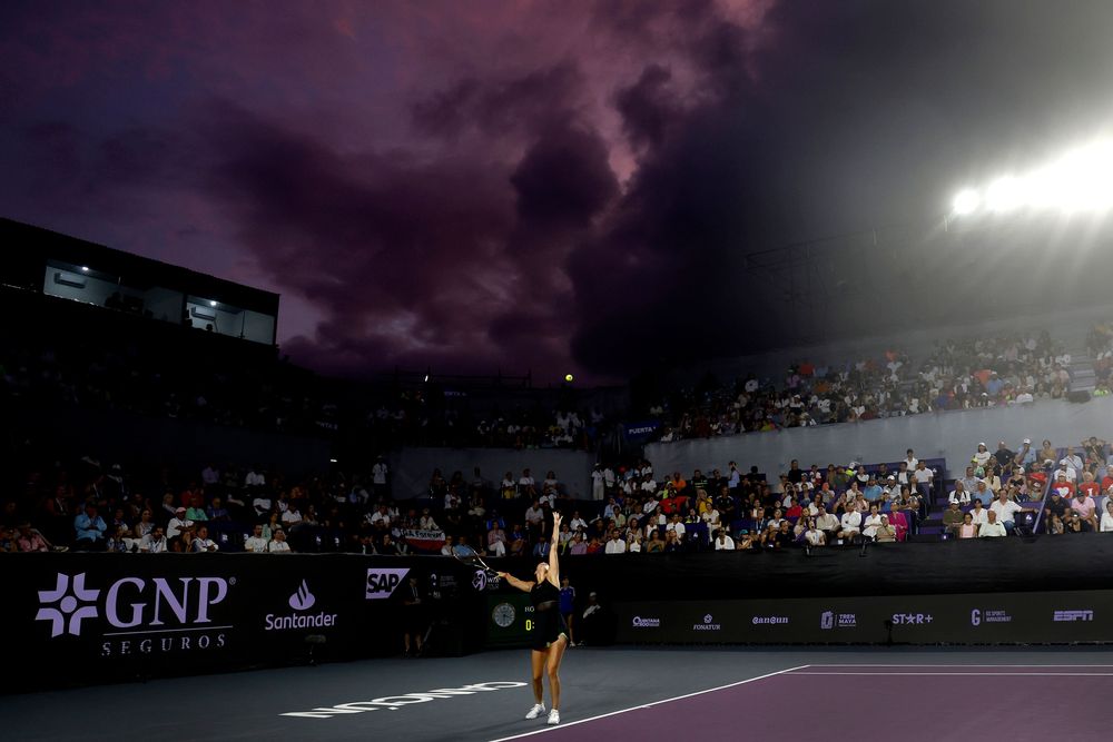 Purple court, purple skies: Aryna Sabalenka is lit up as she serves during her semifinal match.