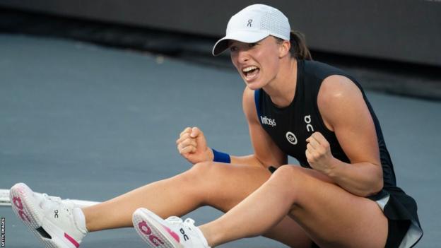 Iga Swiatek celebrates on the court after winning the WTA Finals tournament in Cancun