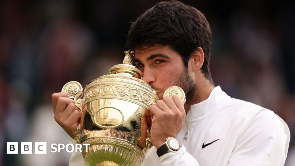 Carlos Alcaraz kisses the Wimbledon men's singles trophy